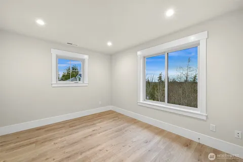 an empty room with wooden floor and a window