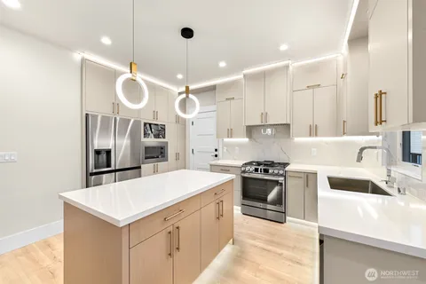 a kitchen with stainless steel appliances a stove a sink and a refrigerator