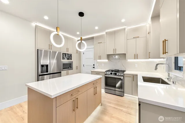 a kitchen with stainless steel appliances a stove a sink and a refrigerator