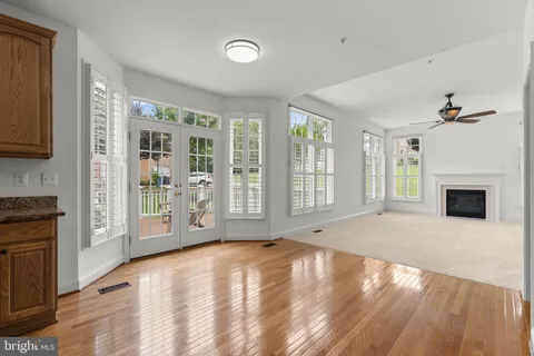 a view of an empty room with a window and kitchen view