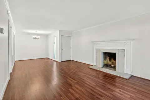 an empty room with wooden floor and fireplace