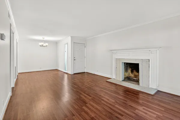 an empty room with wooden floor and fireplace