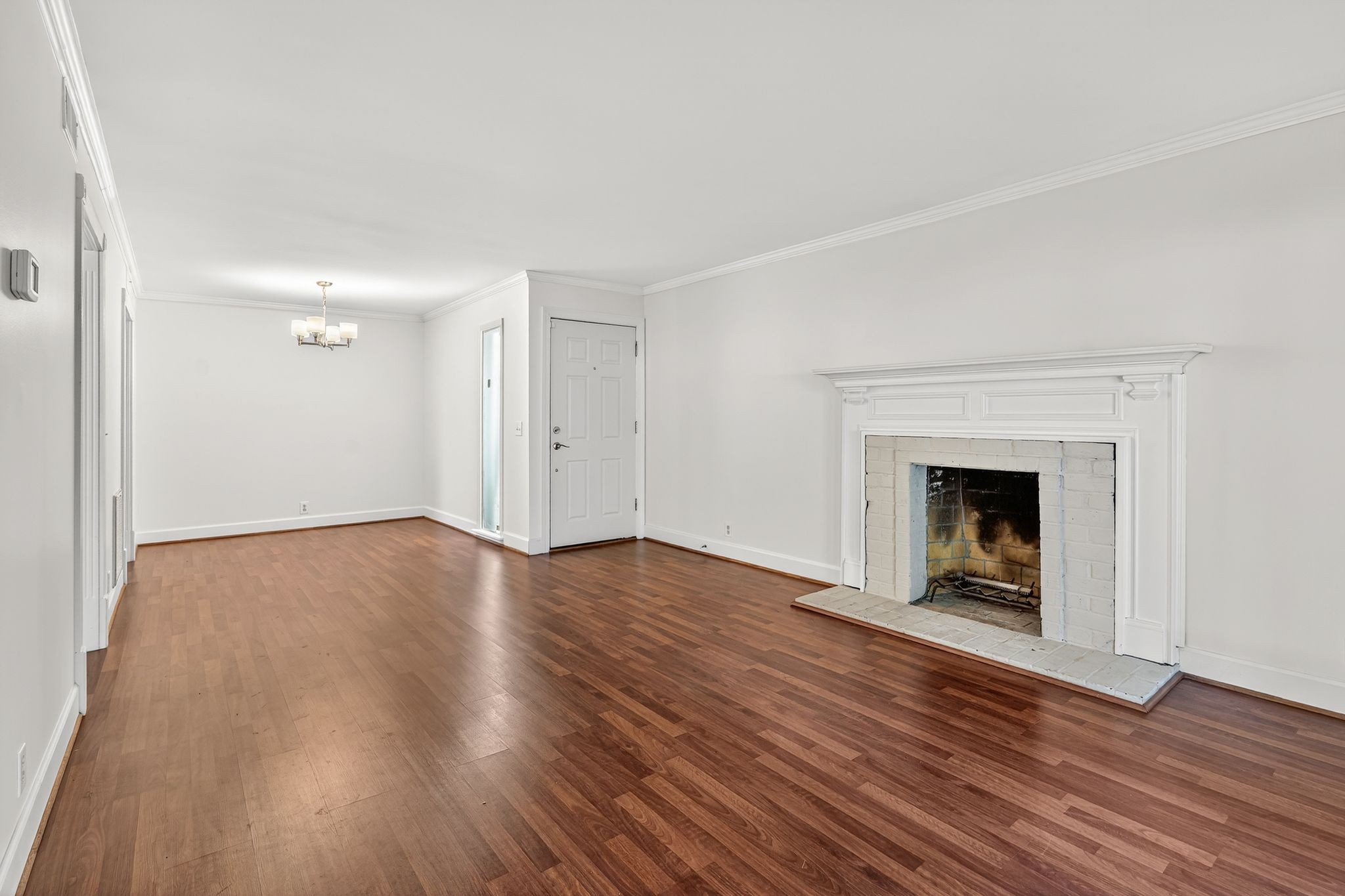an empty room with wooden floor and fireplace