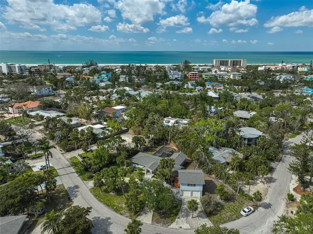 an aerial view of multiple houses with a yard