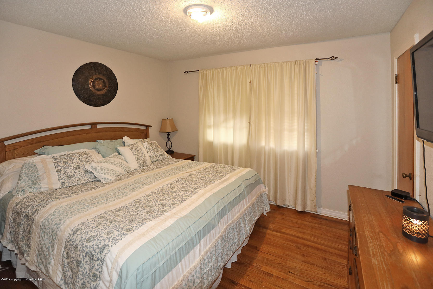 3814 South Monroe Street Amarillo, TX 79110 - Photo 10 of 22 a bedroom with a bed and a chandelier