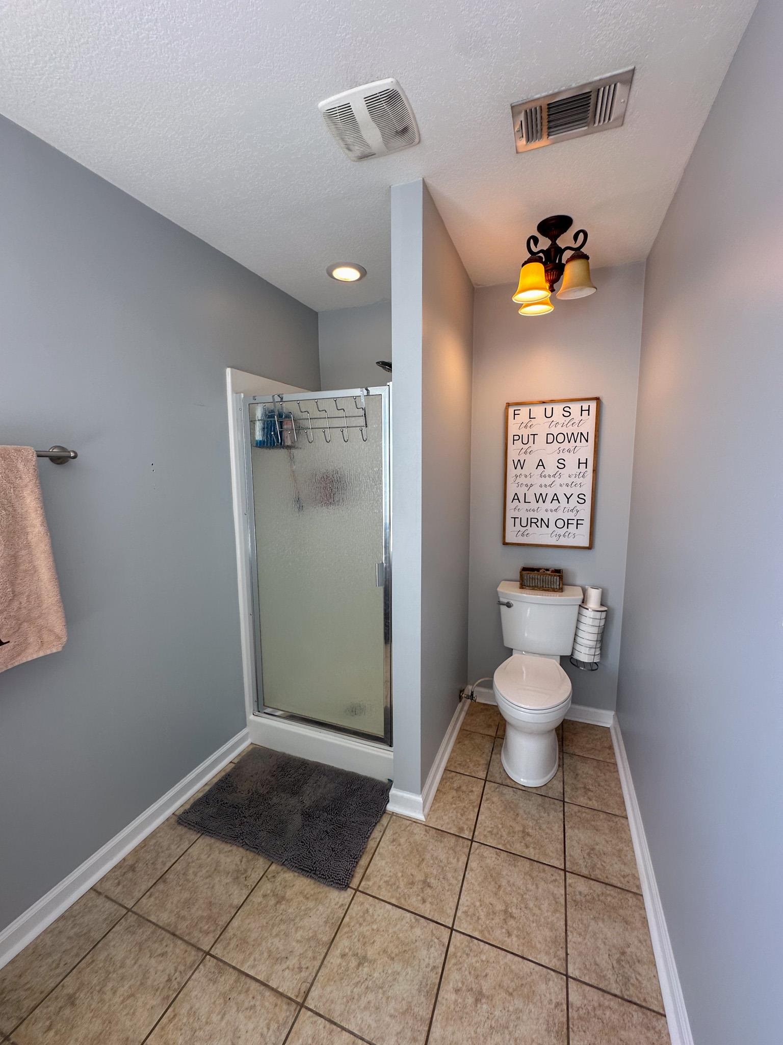 2 Raptor Drive Belmont, MS 38827 - Photo 11 of 18 Bathroom with a shower with door, a textured ceiling, toilet, and tile patterned floors