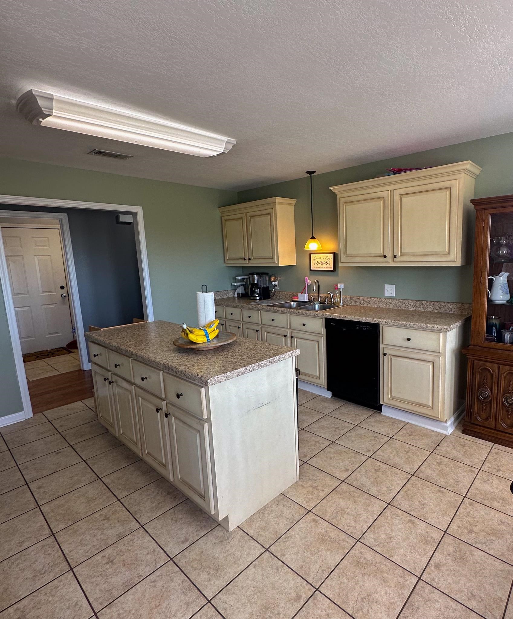 2 Raptor Drive Belmont, MS 38827 - Photo 6 of 18 Kitchen featuring light tile patterned floors, cream cabinetry, black dishwasher, pendant lighting, and sink