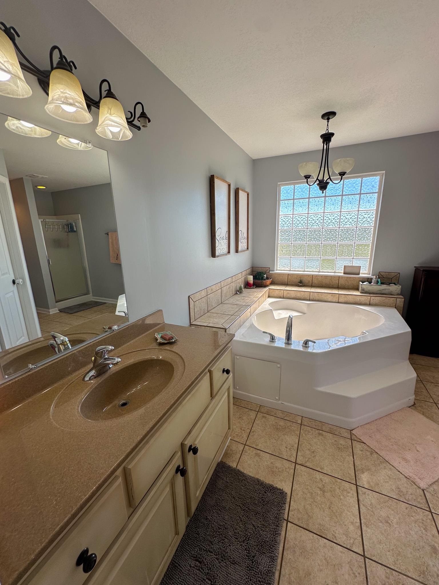 2 Raptor Drive Belmont, MS 38827 - Photo 9 of 18 Bathroom with a tub, tile patterned floors, vanity, and an inviting chandelier