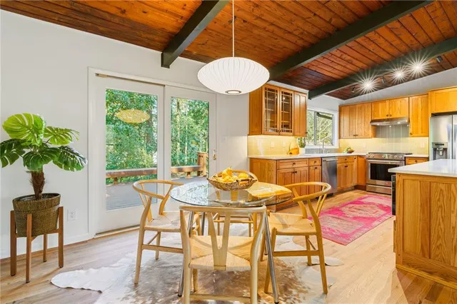 a large kitchen with stainless steel appliances granite countertop a sink and wooden cabinets