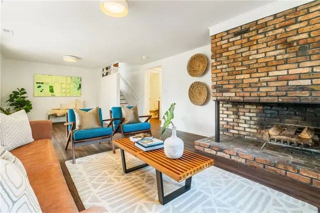 a living room with furniture a table and wooden floor