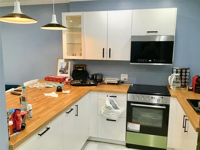 a kitchen with stainless steel appliances granite countertop a stove a sink and a microwave