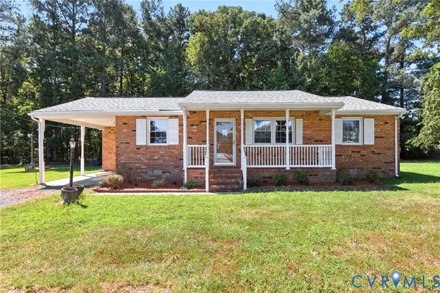 a view of a house with a yard and sitting area