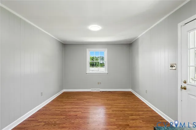 a view of empty room with wooden floor