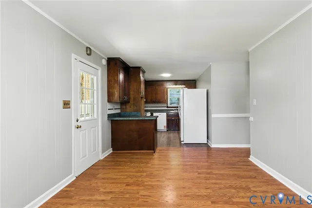 a view of kitchen with refrigerator and wooden floor