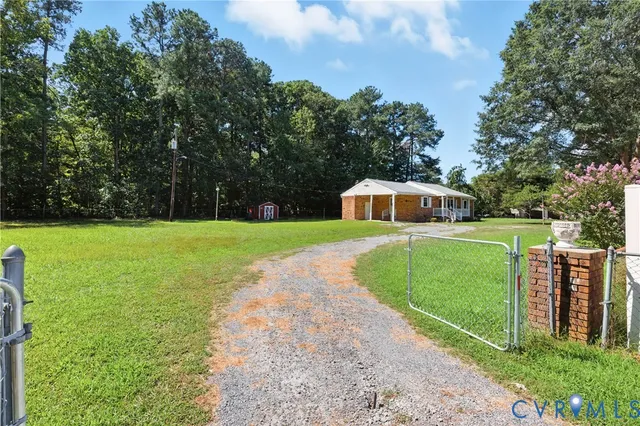 a view of a house with backyard and trees