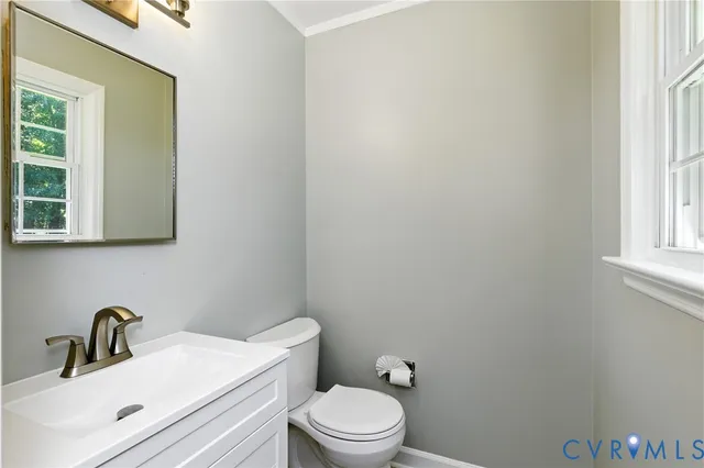 a bathroom with a sink a toilet and a window