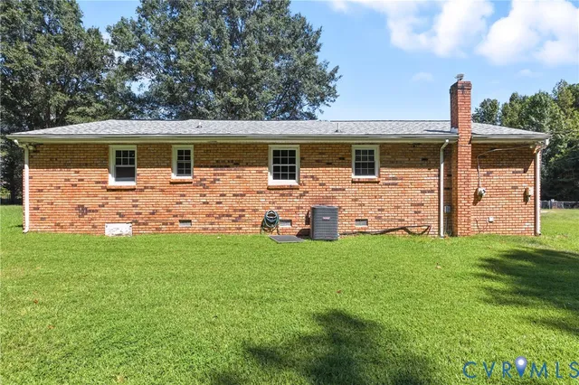 a front view of house with yard and trees in the background