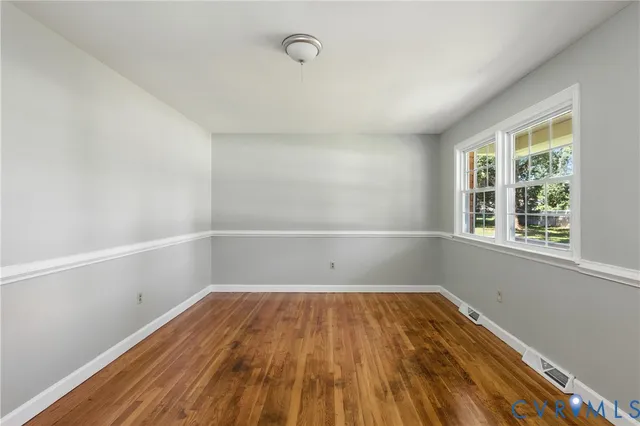 a view of a room with wooden floor and windows