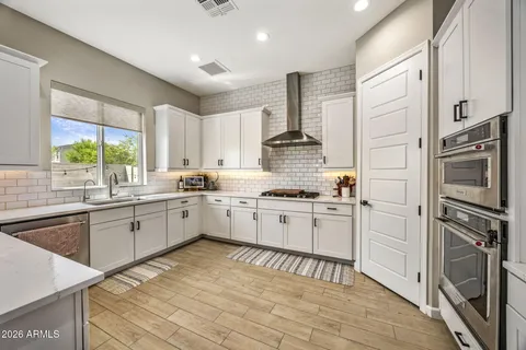 a kitchen with a refrigerator sink and cabinets