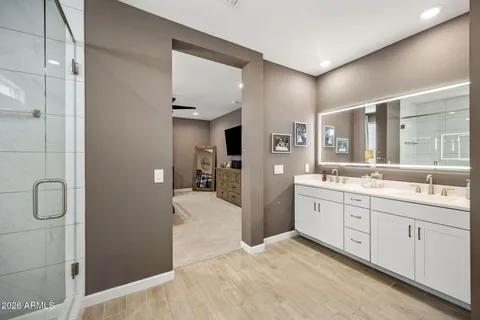 a spacious bathroom with a double vanity sink a large mirror and shower