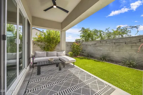 a view of a patio with lawn chairs floor to ceiling window and outdoor kitchen