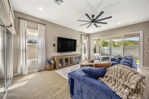 a living room with furniture a flat screen tv and a large window