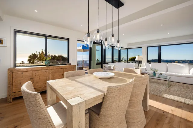a dining table with chairs and kitchen view