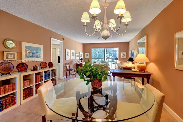 a view of a dining room with furniture a chandelier and wooden floor