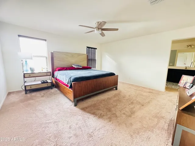a spacious bedroom with a bed and a chandelier