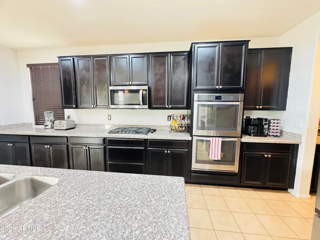 a kitchen with kitchen island granite countertop wooden cabinets and stainless steel appliances