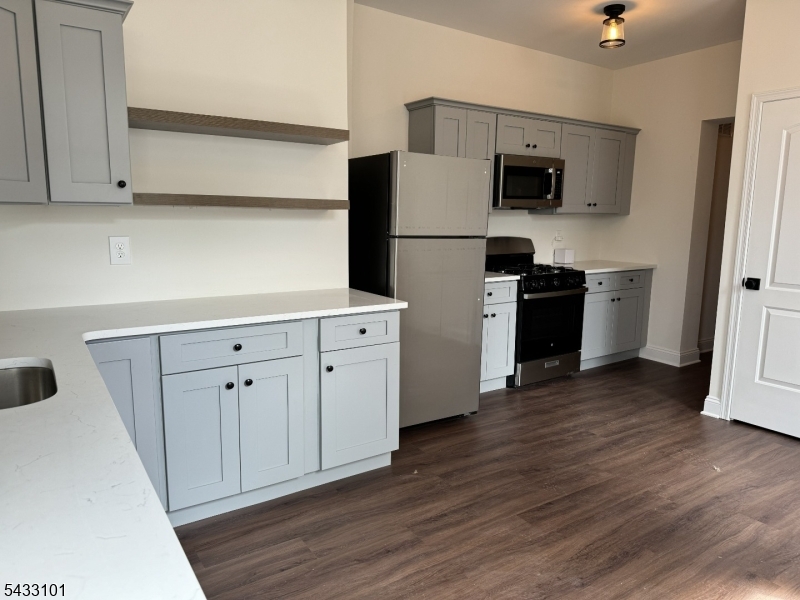 43 1st Avenue, Unit 1 Raritan, NJ 08869 - Photo 2 of 4 a kitchen with cabinets stainless steel appliances and wooden floor