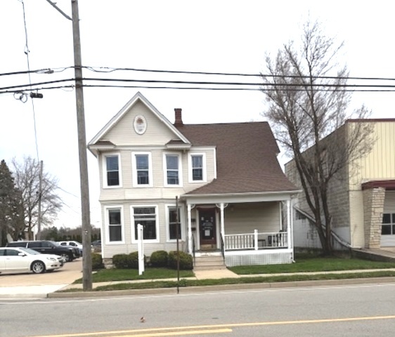 a front view of a house with a garden and parking
