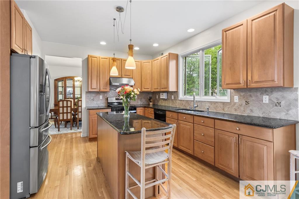 104 Mundy Avenue Edison, NJ 08820 - Photo 14 of 55 a kitchen with stainless steel appliances granite countertop a stove a sink dishwasher and a refrigerator with wooden floor