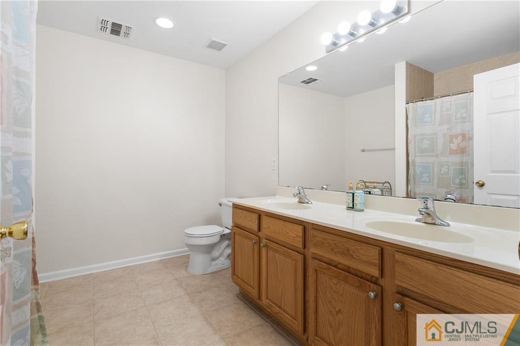 104 Mundy Avenue Edison, NJ 08820 - Photo 32 of 55 a bathroom with a double vanity sink toilet and a mirror