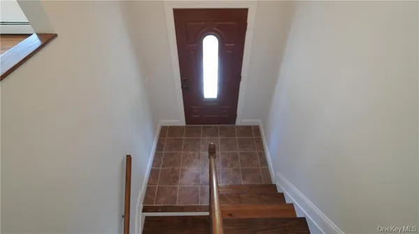 a view of a hallway with wooden floor and stairs