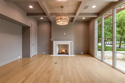a view of an empty room with a fireplace and a window