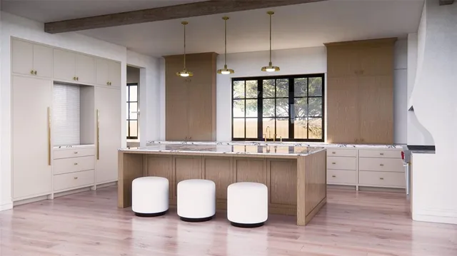 a kitchen with kitchen island granite countertop a stove a sink and white cabinets with wooden floor