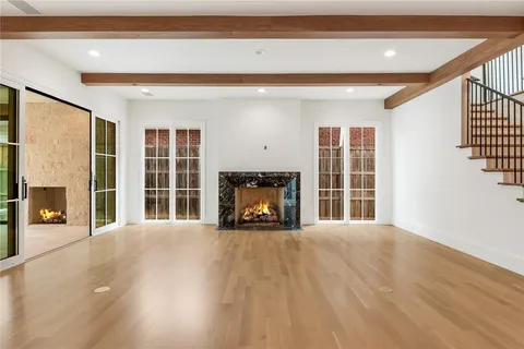 a view of a big room with wooden floor and windows