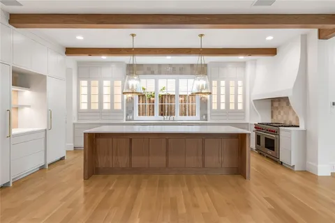 a view of kitchen with stove and cabinets