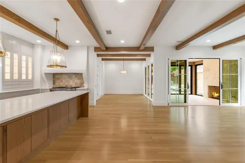 a large kitchen with stainless steel appliances a large counter top a stove and a refrigerator