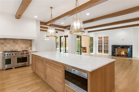 a large kitchen with stainless steel appliances granite countertop a stove and a sink with large window