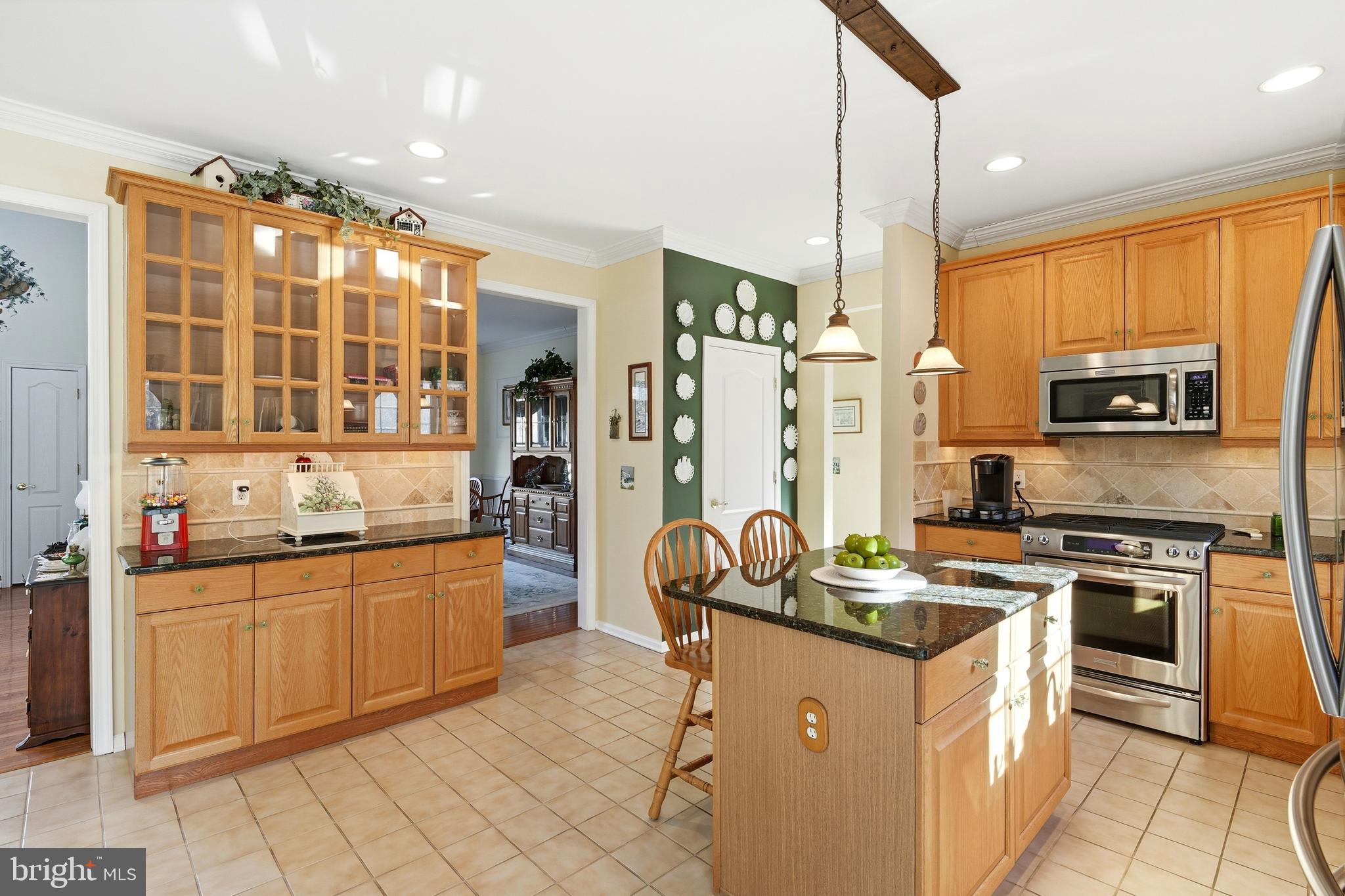 27 Rodeo Drive West Creek, NJ 08092 - Photo 16 of 52 a kitchen with stainless steel appliances granite countertop a stove top oven a sink dishwasher a dining table and chairs with wooden floor