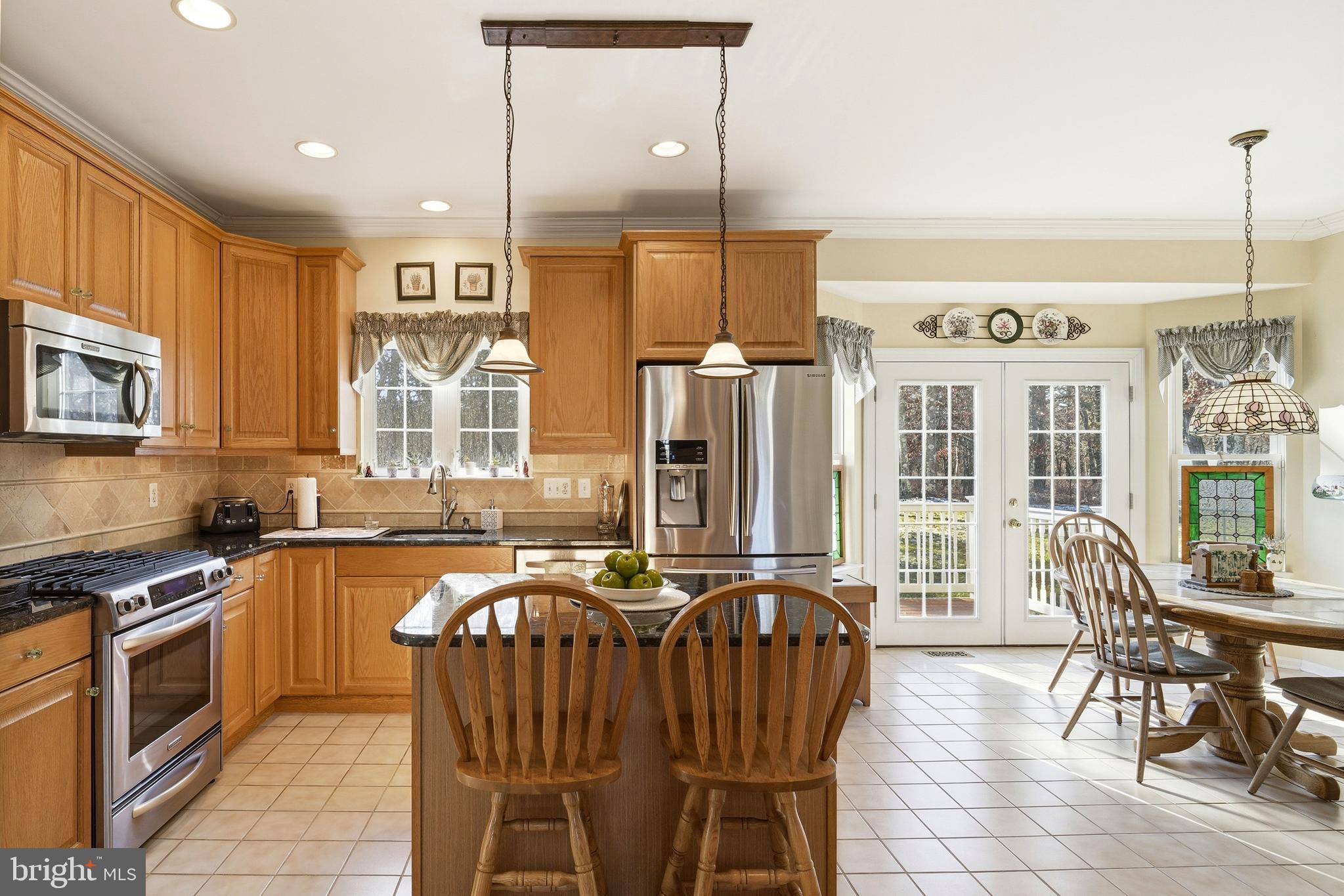 27 Rodeo Drive West Creek, NJ 08092 - Photo 17 of 52 a kitchen with stainless steel appliances granite countertop a stove a sink a microwave a dining table and chairs