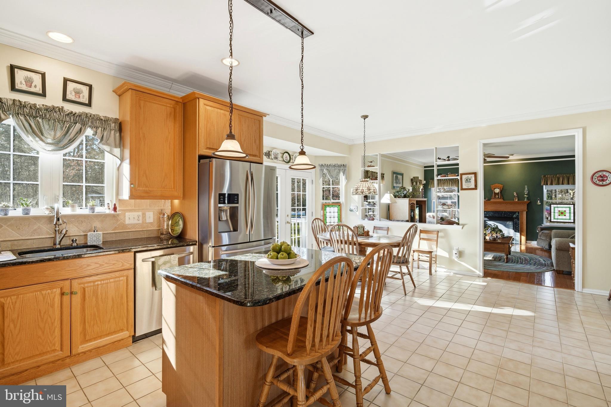 27 Rodeo Drive West Creek, NJ 08092 - Photo 19 of 52 a kitchen with stainless steel appliances kitchen island granite countertop a table chairs in it and wooden floors