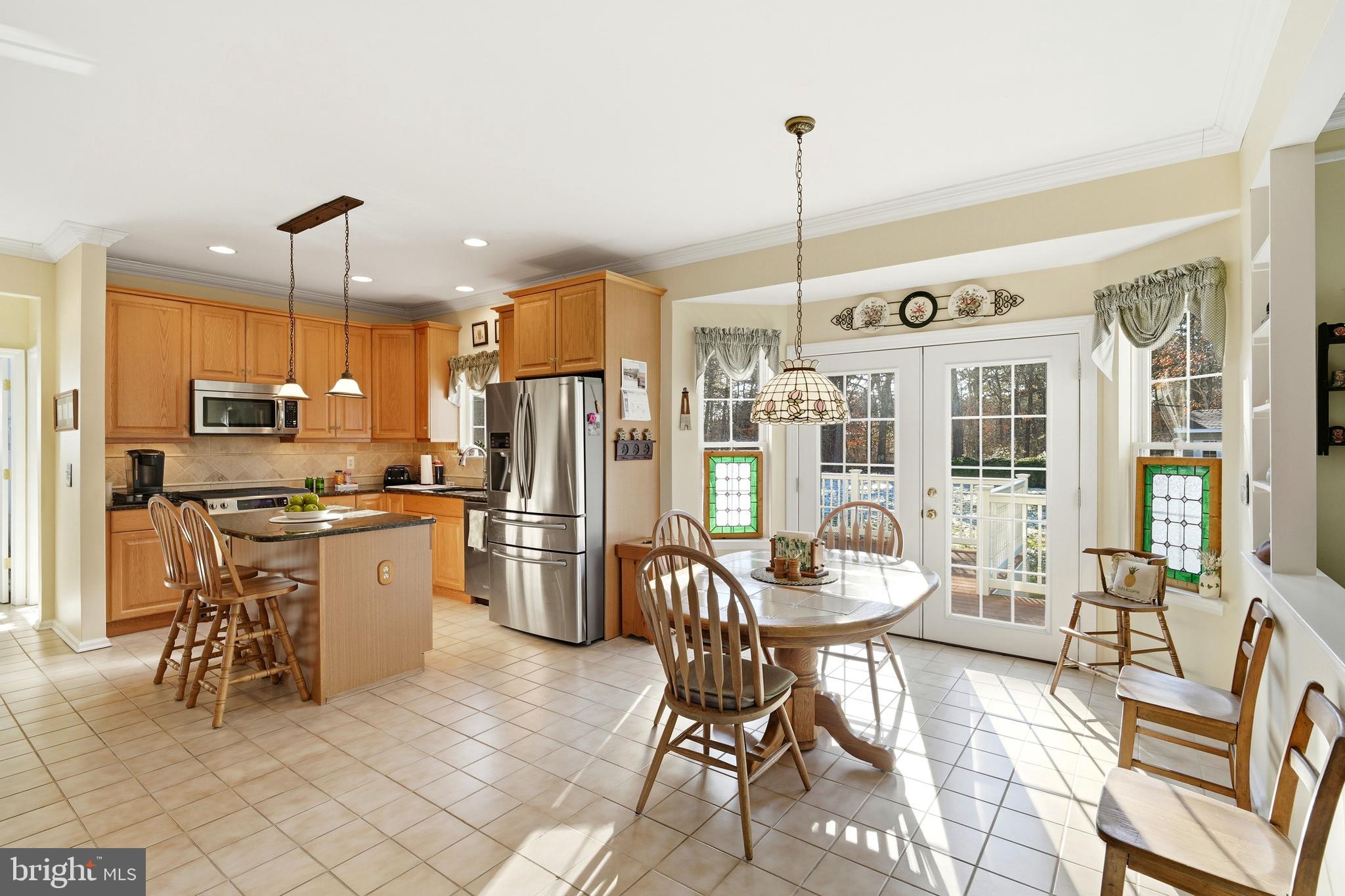 27 Rodeo Drive West Creek, NJ 08092 - Photo 22 of 52 a kitchen with a refrigerator a stove a dining table and chairs