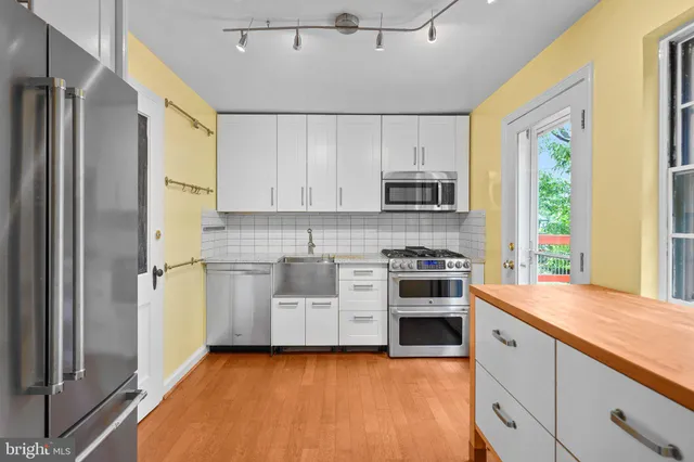 a kitchen with stainless steel appliances a refrigerator sink and microwave