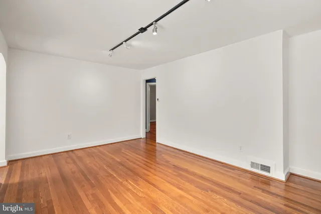 a view of an empty room with wooden floor