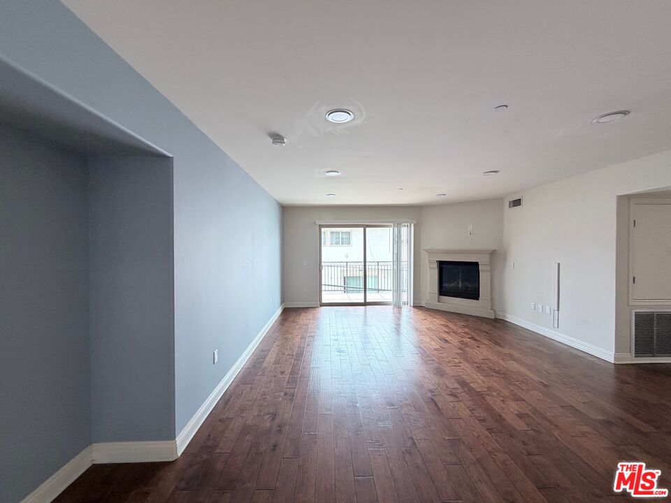 8238 West Manchester Avenue, Unit 308 Playa del Rey, CA 90293 - Photo 3 of 19 a view of empty room with wooden floor and fireplace