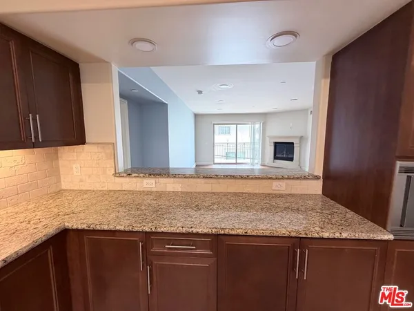 a kitchen with granite countertop cabinets sink and window