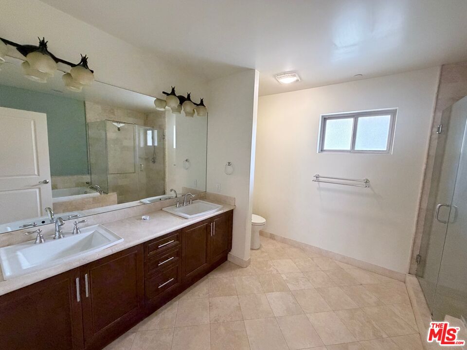 8238 West Manchester Avenue, Unit 308 Playa del Rey, CA 90293 - Photo 10 of 19 a spacious bathroom with a granite countertop sink a toilet and a mirror